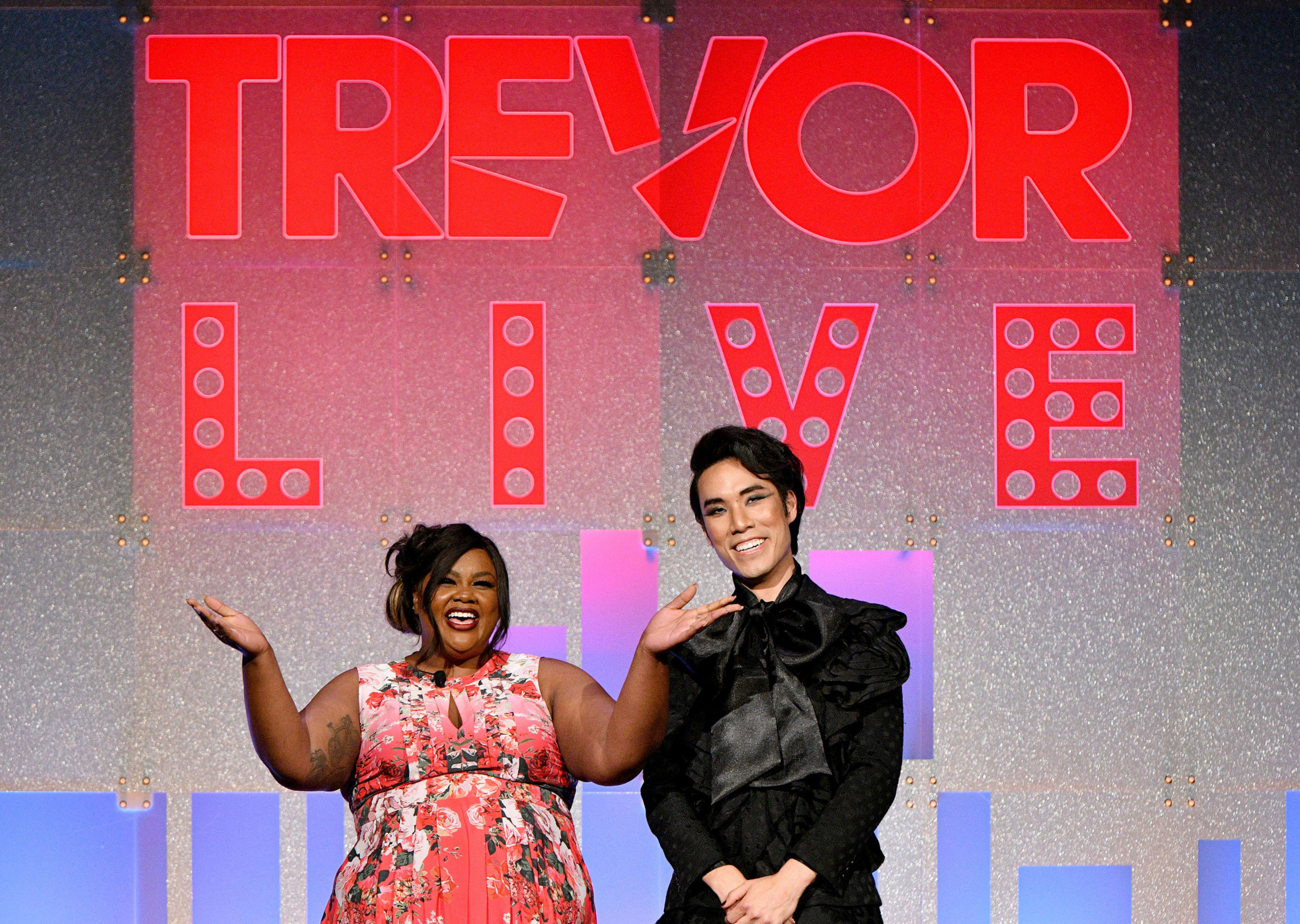 Hosts Nicole Byer and Eugene Lee Yang in front of the TrevorLIVE stage backdrop